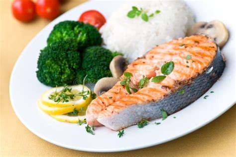 Salmones Asados A La Parilla Con Clos Del Arroz Y Del Tomate Del