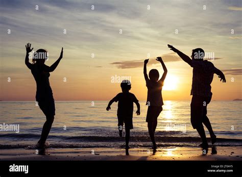 Silueta De Familia Feliz Que Jugando En La Playa Al Atardecer La Gente