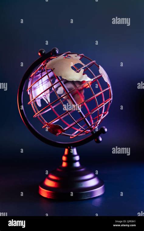 Close Up Metallic Model Of A Globe With Map In Blue And Red Neon Light