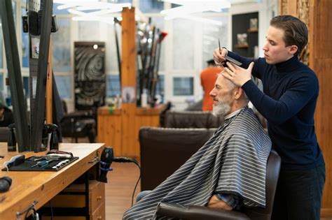 Hombre de tiro medio cortándose el pelo Foto Gratis