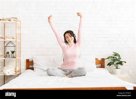 Energetic young woman singing and dancing in bed Stock Photo - Alamy