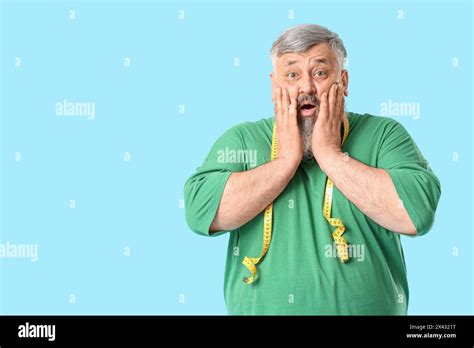 Overweight Shocked Mature Man With Measuring Tape On Blue Background