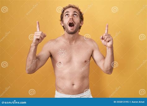 Caucasian Man Standing Shirtless Wearing Sun Screen Amazed And