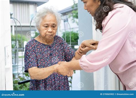 Caregiver Help And Support Asian Senior Woman While Walking Stepping