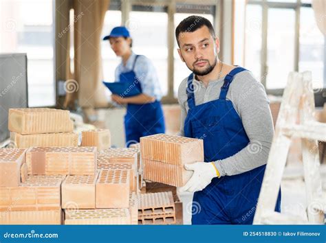 Builder Carrying Bricks While Working In Apartment Stock Photo Image