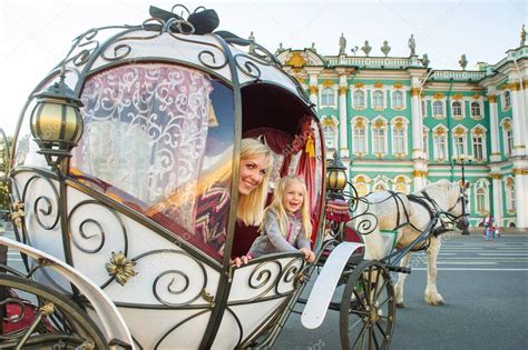 Una niña con un niño en un viejo carruaje en la Plaza del Palacio en