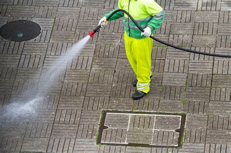 Trabajador Sosteniendo Una Manguera Limpiando Una Acera Con Agua