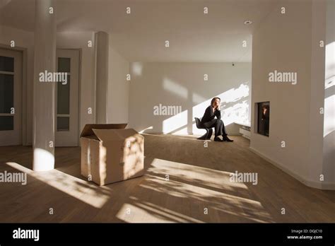 Woman Sitting On Chair In Empty Room Stock Photo Alamy