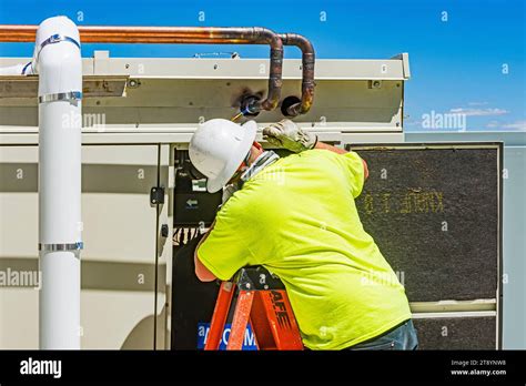 Construction Worker Brazing Copper Pipes At A Compressor Housing On The