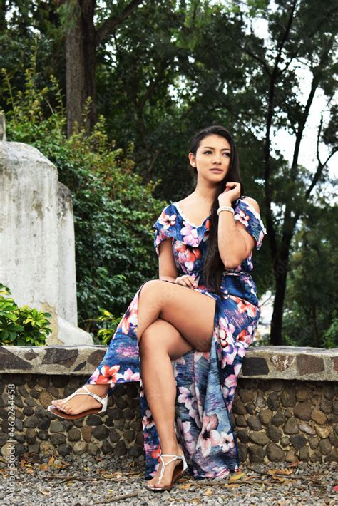 Retrato De Una Mujer Joven Latina Con Un Vestido Azul Flores Rojas Y