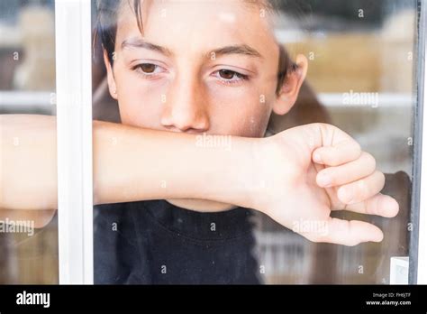 Pensive Boy Looking Through Window Stock Photo Alamy