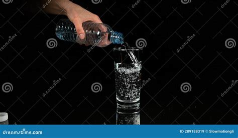 Water Being Poured Into Glass Against Black Background Stock Image