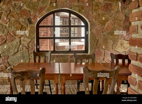 Rustic Stone Built Restaurant Interior With Wooden Tables And Chairs