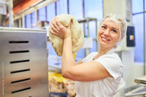 Bäcker Lehrling in der Ausbildung transportiert Teig foto de Stock