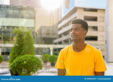 Portrait Of Handsome Black African Man Wearing Yellow T Shirt Outdoors