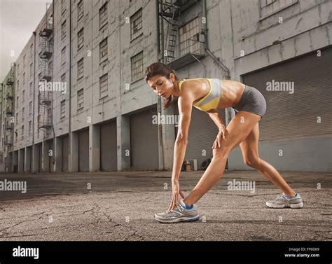 A Woman In Running Gear Crop Top And Shorts Stretching Her Body And