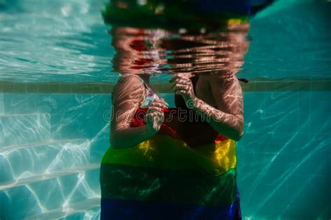Dos Mujeres En La Piscina Juntas Envueltas Con La Bandera Gay Arcoiris