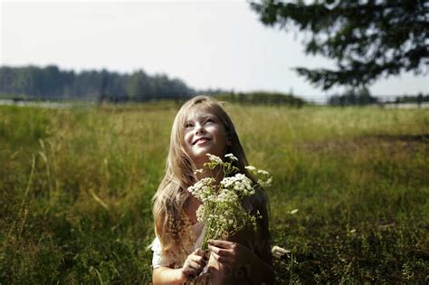 Kaukasisches Mädchen hält einen Strauß Wildblumen im Feld lizenzfreies