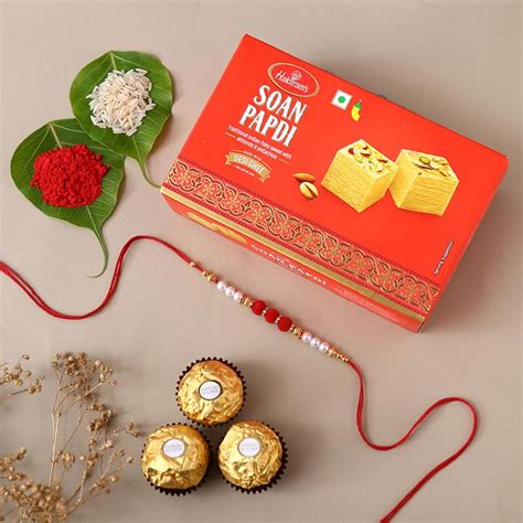 Send White Pearl And Velvet Beads Rakhi With Grams Soan Papdi And