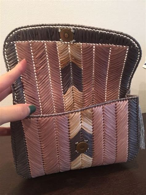 A Woman S Hand Is Holding Onto A Purse That Has Been Made Out Of Woven