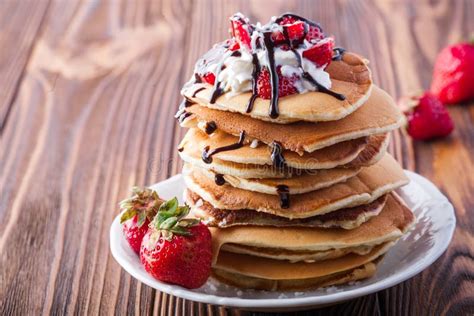 Stack Of Pancakes With Strawberries Whip Cream And Chocolate Syrup On