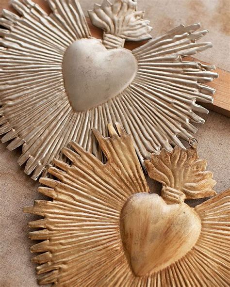 Two Heart Shaped Brooches Sitting Next To Each Other On Top Of A Table