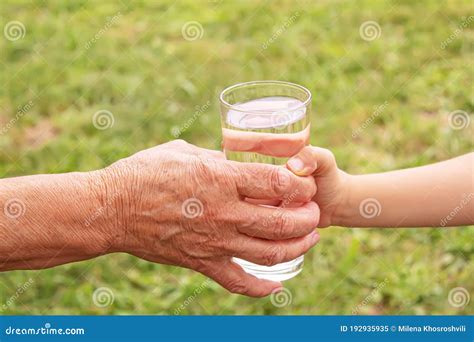 Mormor Som Ger Ett Glas Rent Vatten Till Ett Barn Selektiv Fokusering