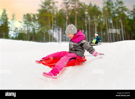 Happy Little Girl Sliding Down On Sled In Winter Stock Photo Alamy