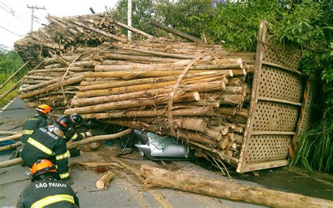 FOTOS Motorista sai ilesa após ter carro esmagado por toras de madeira