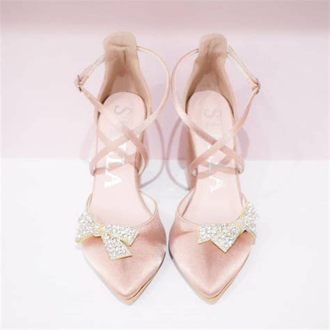 A Pair Of Pink Shoes With Bows On Them