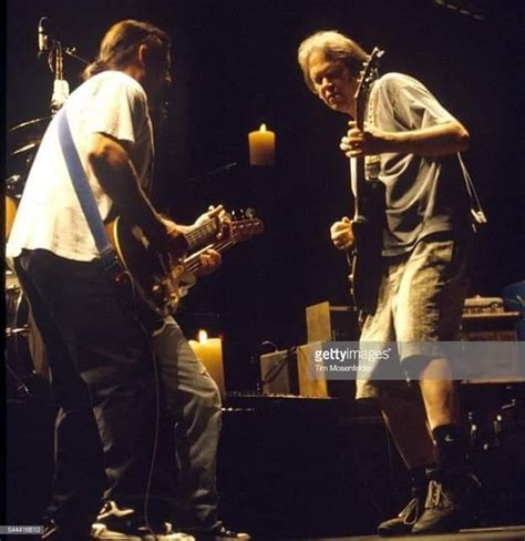 Two Men Are Playing Guitars On Stage