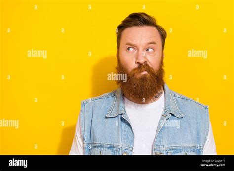 Photo Of Doubtful Unsure Man Wear Jeans Waistcoat Looking Empty Space Isolated Yellow Color