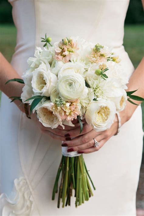 A Bride Holding A Bouquet Of White Flowers