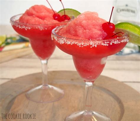 Two Glasses Filled With Watermelon Margaritas On Top Of A Wooden Table