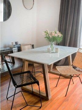 A White Table And Chairs In A Room With Wood Flooring Next To A Window