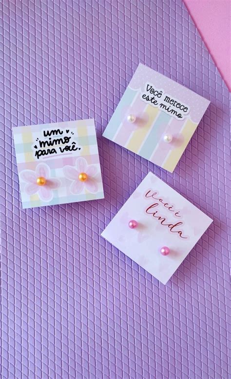 Three Small Greeting Cards With Pearls And Writing On Them Next To A