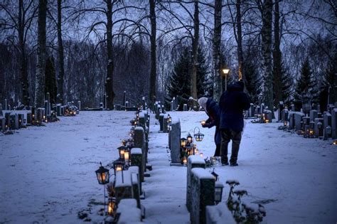 Varias Personas Colocan Velas Junto A Las Tumbas En Un Cementerio En