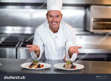 Portrait Of Smiling Happy Chef Showing Food Plates In Commercial