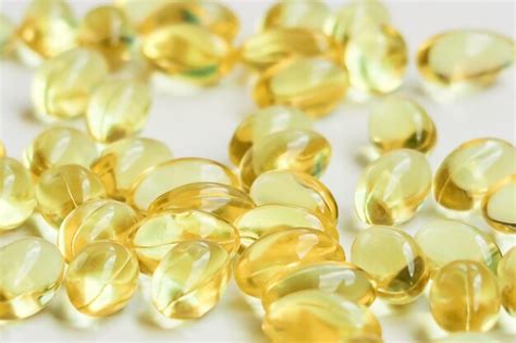 Premium Photo Yellow Vitamin Capsules On A White Background Food