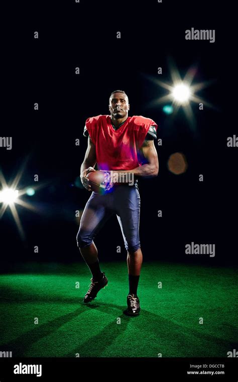 American football player holding ball Stock Photo - Alamy