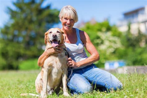 Mogen Kvinna Med Hunden Som Tar Foto Med En Kamera Fotografering F R