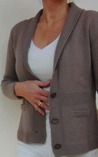 A Woman In White Pants And A Brown Jacket Is Posing For The Camera With