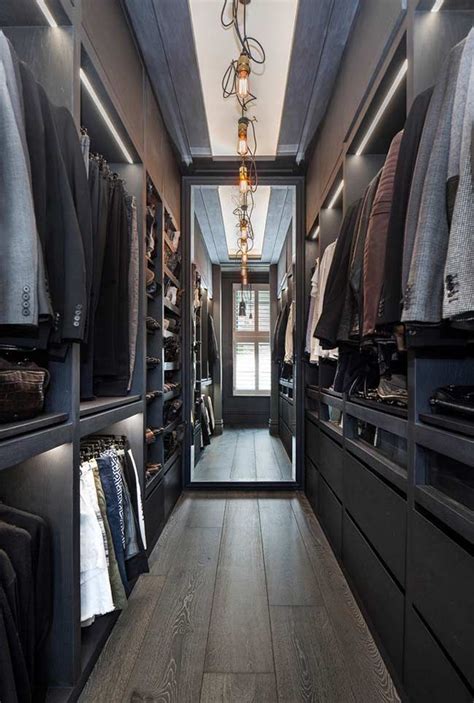 A Walk In Closet With Lots Of Clothes On Shelves And Lights Hanging