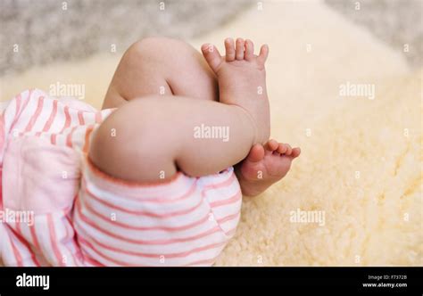 A Baby Lying On A Sheepskin Rug Kicking Her Legs Stock Photo Alamy