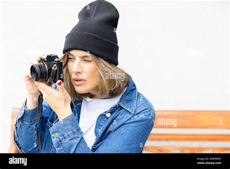 An Engaged Photographer With A Vintage Camera Focuses Intently On Her