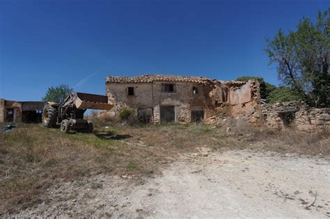 Uma Casa No Meio De Um Campo Uma Grande Escavadeira Na Frente