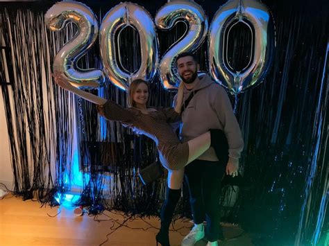 a man and woman posing in front of balloons with the numbers 2050 on them