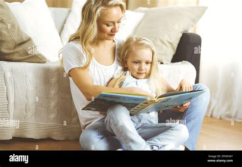 Bonne Famille Une Jeune Mère Blonde Lit Un Livre à Sa Jolie Fille Tout