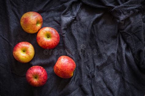 Red Apples In A Black Bowl On A Black Fabric Background Stock Photo