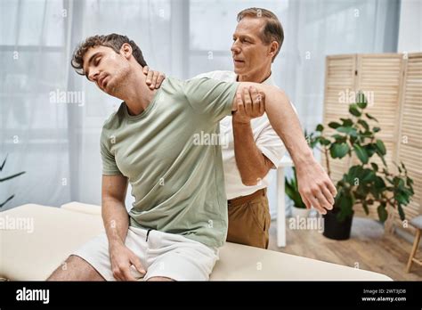 Attractive Mature Doctor In Uniform Helping His Appealing Patient To